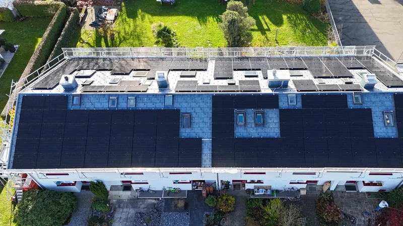 Reiheneinfamilienhäuser in Grüt von oben, das PREFA-Metalldach ist über alle sechs Einheiten mit Solarmodulen belegt