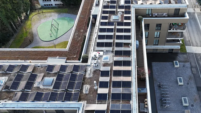 Wohnüberbauung in Uster aus der Luft, begrünte Flachdächer vollflächig mit Solarmodulen belegt